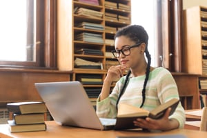 Studenti concentrati nello studio con libri e strumenti digitali